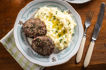 Minced meat cutlets with mashed potatoes topped with clarified butter. Traditional Slovak meatballs - Fasirky with potato puree.