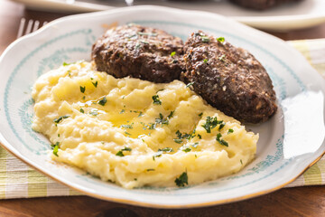 Mashed potatoes topped with melted butter as a side dish to meatballs - 788236818