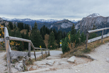 Wooden fence at the top of Alps in Bavaria, surrounded by mountains and trees.