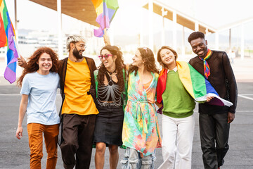 Happy group of people having fun with rainbow flags on a walking during gay pride day