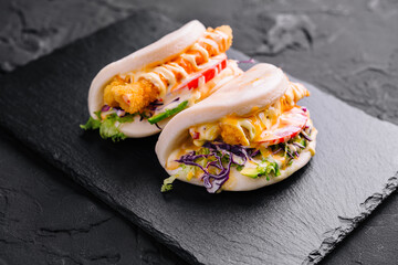 Delicious bao buns with crispy chicken and fresh vegetables