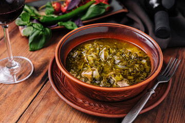 Homemade rustic kale soup in terracotta bowl