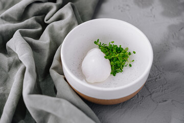 Poached egg with microgreens on ceramic plate