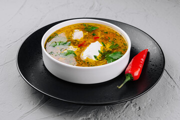 Homemade spicy soup with herbs and cream