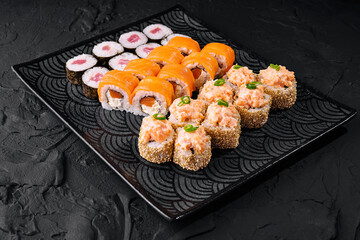 Assorted sushi platter on black slate background