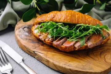 Gourmet croissant sandwich with arugula and ham