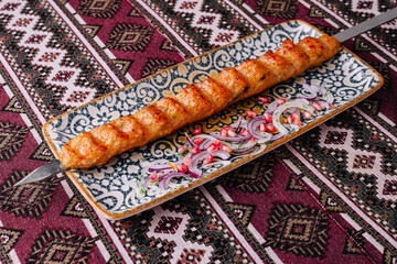 Traditional chicken kebab on ornate plate
