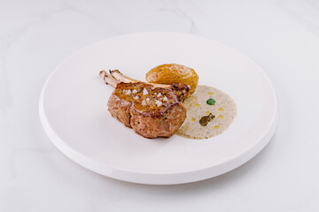 Gourmet lamb chop on elegant white plate