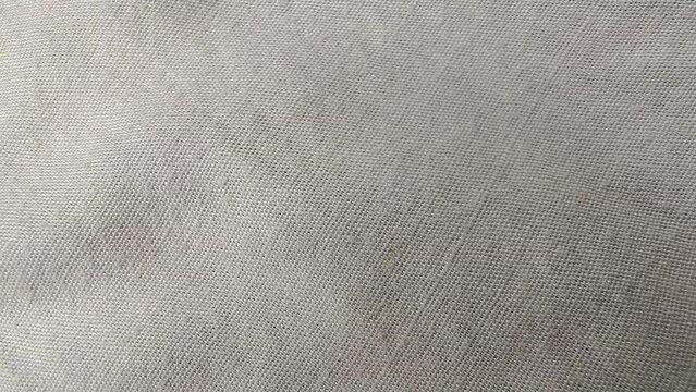 Luxury and elegant white color wrinkled linen cloth fabric sheet or canvas surface background texture closeup macro overlay top view. Fashion and textile industry abstract stop motion animation.