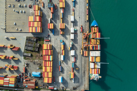 Aerial view of cargo port with container terminal at dock. International freight logistics and trade commerce transportation.