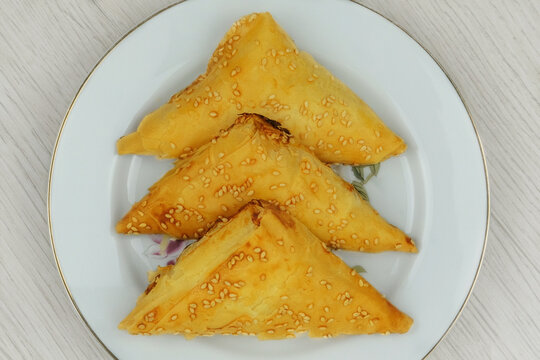 Eastern cuisine. Samosas in a plate on a white background. Homemade food. Fast food. Top view.