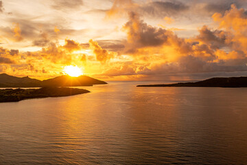 Golden sunset over ocean with incredible colorful sky background. Mountains with sun's rays. Fiji.