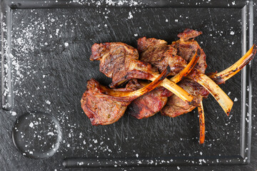 Lamb chops. Close up photo with some lamb chops grilled on barbecue and placed on a black plate...
