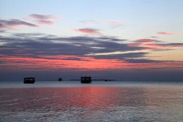 Silhouettes of boats in the water on gorgeous sunset over the ocean