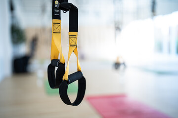 A pair of yellow and black straps hanging from a ceiling