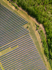 drone view of a solar power station next to a forest during summer. Renewable energy meets nature in action