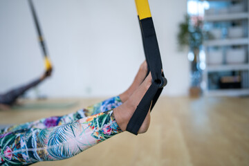A woman is doing a yoga pose with a strap around her feet