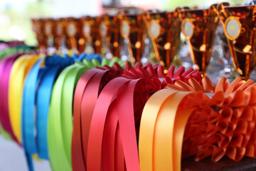 Fototapeta premium Pile of horse riding ribbons and trophy awards. Group of beautiful colorful trophies