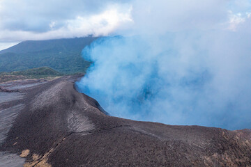 Smoke over volcano crater. Gray clouds ocean background. Vanuatu. Volcano accessible to tourists.