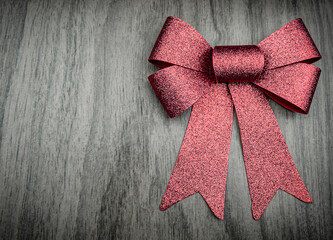 Red shining bow on wooden background