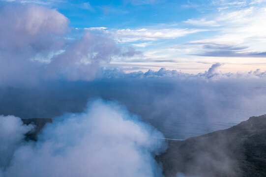 Smoke over volcano crater. Gray clouds ocean background. Vanuatu. Volcano accessible to tourists.