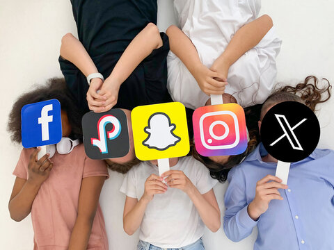 Teenagers hands hold social media signs in their hands: new Twitter logo, Snapchat, Instagram, Tiktok, Facebook. 