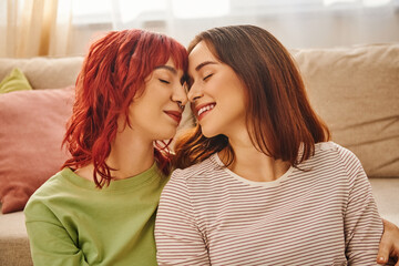 serene moment of happy lesbian couple with closed eyes smiling at home, bliss and love