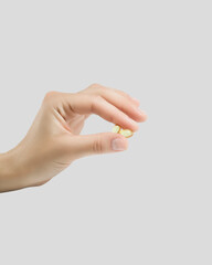 hand holding two vitamin capsules. taking vitamins and nutritional supplements for female beauty...