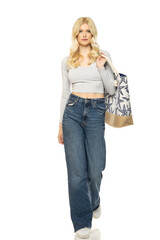 Beautiful young blonde woman in jeans with beach bag on white background