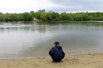 child on the bank of lake