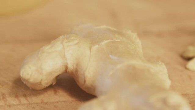 Ginger root on a wooden table. Close up, macro. Studio shot. Interior. Kitchen. High quality 4k footage
