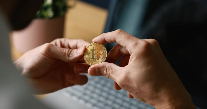 crypto investor holding physical bitcoin in hand