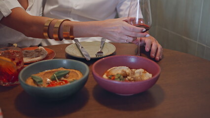 Woman hand holding wineglass at cafe closeup. Spouses tasting lebanese cuisine