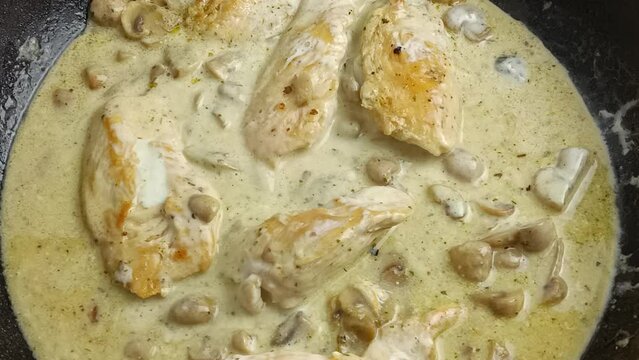 morceaux de poulet, sauce champignons, en cuisson dans une po&ecirc;le.