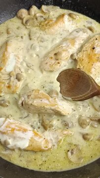 morceaux de poulet, sauce champignons, en cuisson dans une po&ecirc;le.