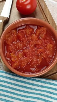 bol de tomates concass&eacute;es, en gros plan, sur une planche &agrave; d&eacute;couper	