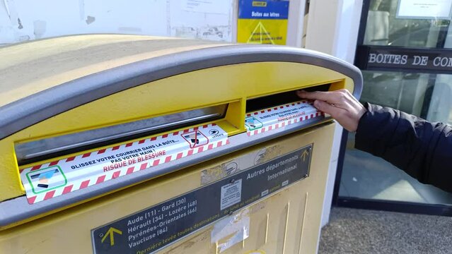 d&eacute;p&ocirc;t d'une lettre dans une boite aux lettre de La Poste.