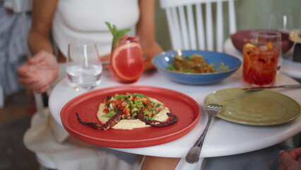 Woman hand holding glass at expensive cafe lunch closeup. Lady enjoying hummus