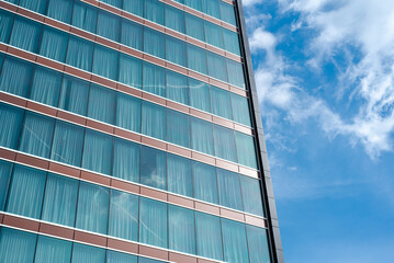 Cloud reflection on glass wall of modern high rise hotel room with blackout curtains in Texas, lookup view office building, skyscraper, futuristic looking architecture