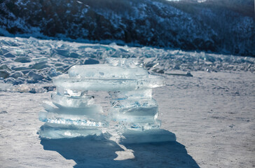 Pieces of ice lying on the ideal smooth ice of baikal with ice hummocks in the horizon