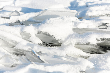 Pieces of ice lying on the ideal smooth ice of baikal with ice hummocks in the horizon