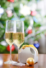 Glasses of champagne and Christmas gift  in front of Christmas tree for the holidays