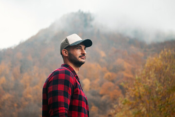Portrait of Handsome Young Man with Cap and Checkered Shirt in Foggy Autumn Forest - 788362824
