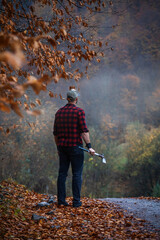 Handsome Strong Young Man in Plaid Shirt in Autumn Forest