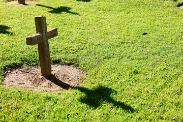religious cross in the cemetery casts a shadow