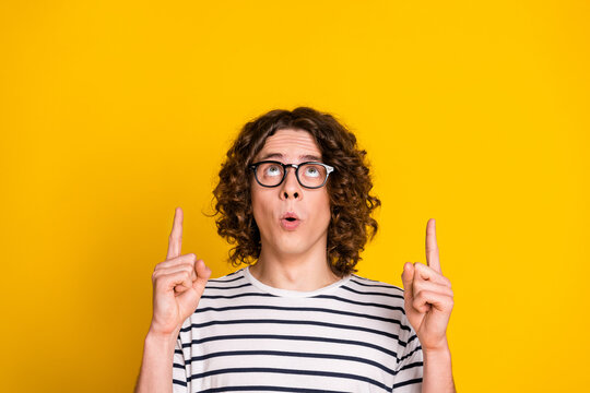 Close up photo of young amazed funny nerd guy direct fingers above head much useful information isolated on yellow color background