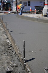 concrete worker putting final touch on wet concrete