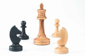 Beautiful chess pieces king surrounded by horses and pawns on white background. Business concept and decision strategies.