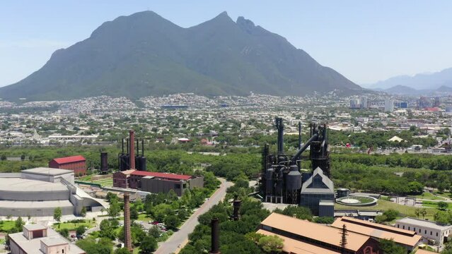 Aerial Panning Shot Of Museo Del Acero Near City By Mountains Against Sky On Sunny Day - Monterrey, Mexico