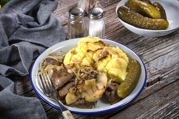 Fried liver with onion and apple, served with boiled potatoes and pickled cucumber.
